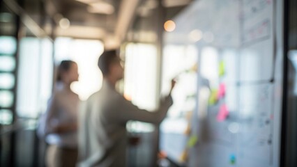 Team Innovation Sprint Blur: A dynamic office environment with blurred colleagues focusing on a whiteboard filled with charts and notes.
