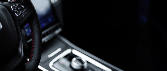 Fototapeta premium A close up of a steering wheel with a black background
