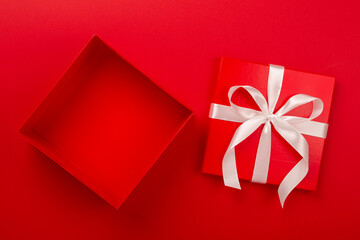 Open red gift box on color background, top view