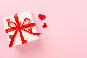 Gift boxes with red hearts on color background, top view