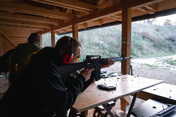 Training shooting weapons at an outdoor shooting range.