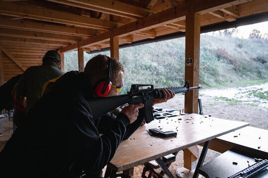 Training shooting weapons at an outdoor shooting range.