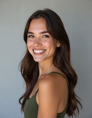 A beautiful young woman with long hair smiles in profile against a soft background, exemplifying confidence and natural beauty in an editorial style perfect for fashion shoots.