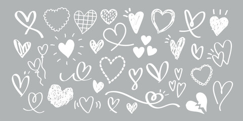 A collection of hand-drawn heart doodles in various styles on a gray background. Heart shapes, doodles, and love symbols in a playful, artistic design. White doodle Valentine's Day vector set.