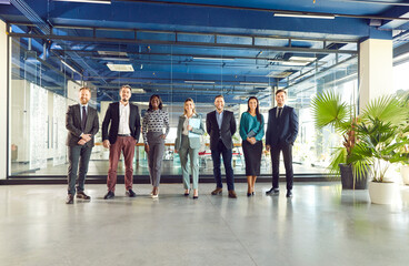 Fototapeta premium Confident diverse professional business team standing in modern office looking at camera, multiracial workers staff group pose together as human resource service tem to show corporate equality 