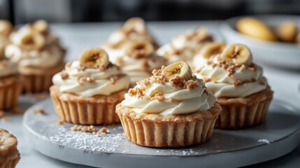 Scrumptious cupcakes topped with cream and banana slices, elegantly arranged on a plate, perfect for dessert lovers.