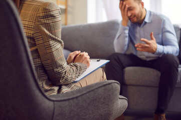 A young man cries in front of a psychologist, close-up. Concept for psychological help, emotional...
