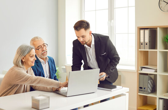Financial consultant, adviser, broker or real estate agent is consulting a senior couple in an office. The meeting focuses on insurance, financial planning, and investment advice.