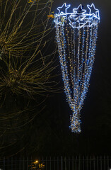 Normandy, France -12- 30- 2024 : Exterior night photo view of christmas light decorations for xmas celebrations decor evening with garlands and tinsel lights,