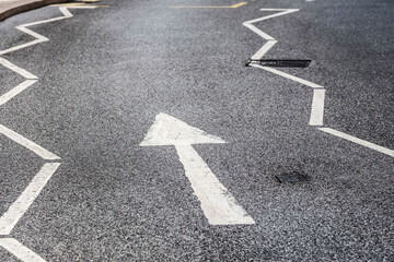 This image features a close-up of a zigzagged road marking directing traffic, emphasizing urban navigation and the importance of transportation in city living.