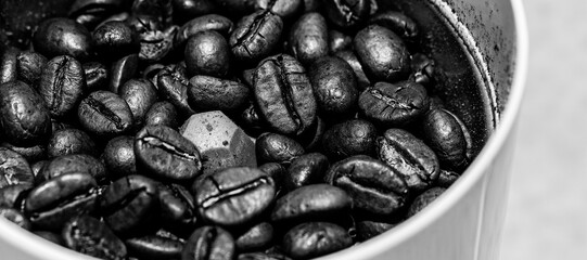 Vue de près sur des grains de café dans un moulin à grains, avec effet noir et blanc brillant
