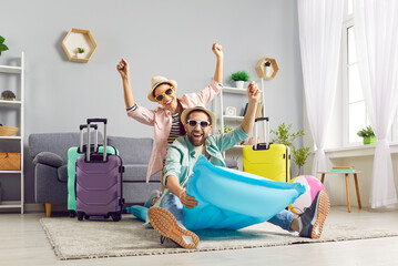 Positive, happy family couple expresses excitement for upcoming summer vacation while sitting...