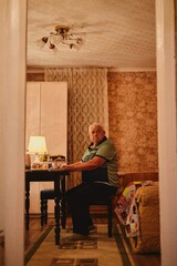 Portrait of a gray-haired grandfather celebrating a family holiday with his relatives in a cozy atmosphere
