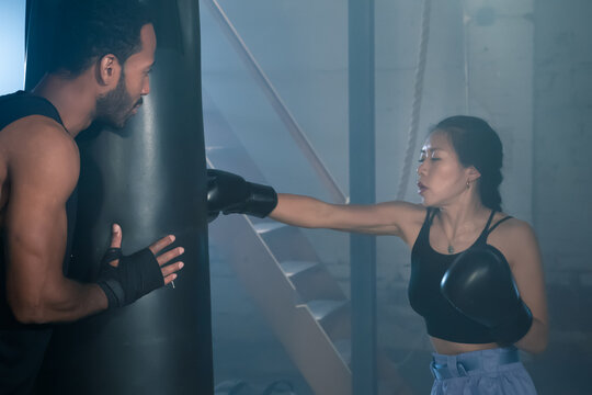 Pretty young woman trains in boxing sparring with male. High quality photo