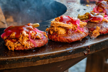 Delicious tacos al pastor being cooked on a hot grill at a busy outdoor market in Mexico during the late afternoon