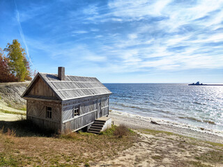 Tranquil wooden cabin by the serene beach under a clear blue sky in autumn