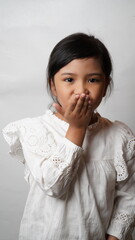 Portrait of an Asian girl wearing a white shirt posing for a kiss bye on a white background.
