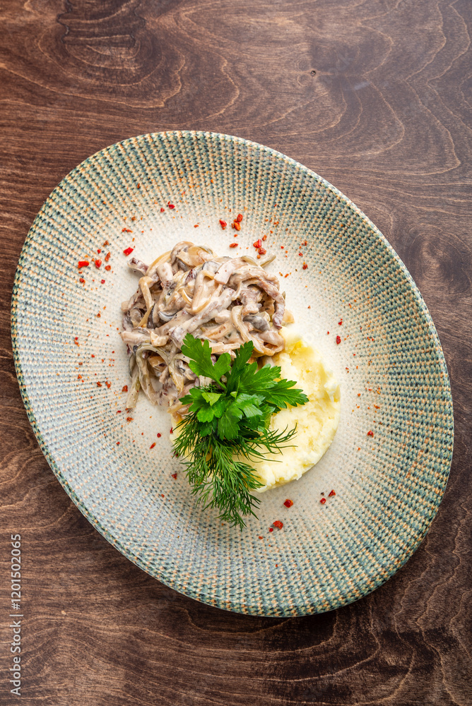 Wall mural A delicious plate featuring creamy mushroom stew served with fluffy mashed potatoes. Garnished with fresh parsley and dill, the dish is sprinkled with red pepper for a vibrant touch.