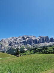View from Val Gardena, Sassolungo, Italian Dolomites. Idyllic mountain valley view under a clear blue sky, mountains in the distant