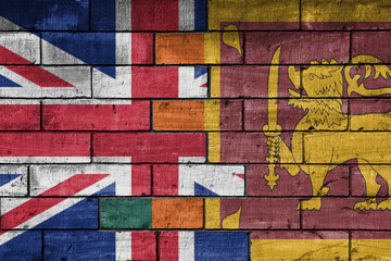 colourful painted big flag of great britain and flag of sri lanka on a massive old brick wall...