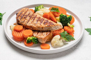 Grilled chicken breast and broccoli, cauliflower and carrots. Chicken meat with vegetables. Healthy food. White background top view