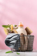 Basket with eco-friendly cleaning tools on pink background. Zero waste cleaning, spring cleaning...