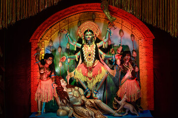 Fototapeta premium Idol of Goddess Maa Kali at a decorated puja pandal in West Bengal, India, during Kali puja, a famous religious festival of Hinduism.