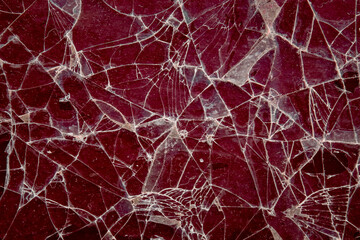 Pattern on cracked glass. damage to glass. cracked texture on red background