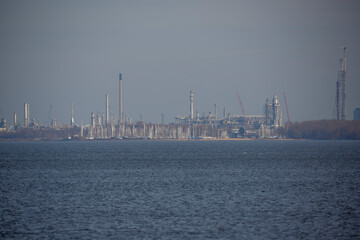 Naklejka premium Factories along the waterfront under a clear sky in an industrial area during the day