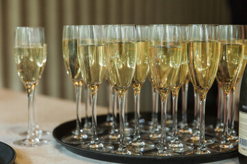 Glasses of champagne on a tray at a wedding reception close-up