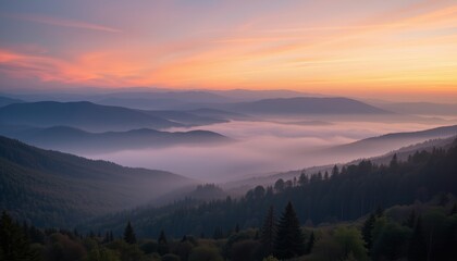 Fototapeta premium Foggy mountain valley at sunrise with layers of mist