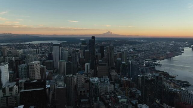 Scenic view of downtown district and Seattle waterfront with orange horizon and Mt Rainer