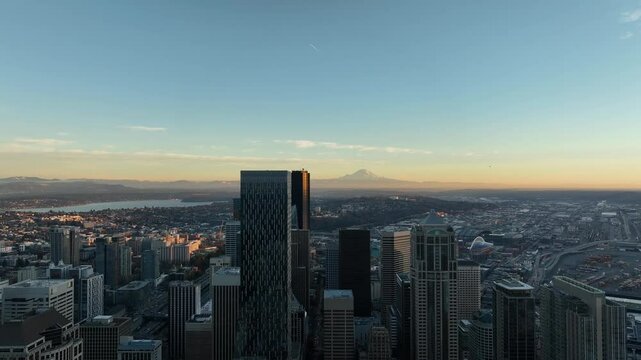 Skyscrapers tower over Seattle cityscape with Mt Rainer on a blue sky horizon