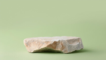 Minimalist stone podium on light green background for natural cosmetic advertising.