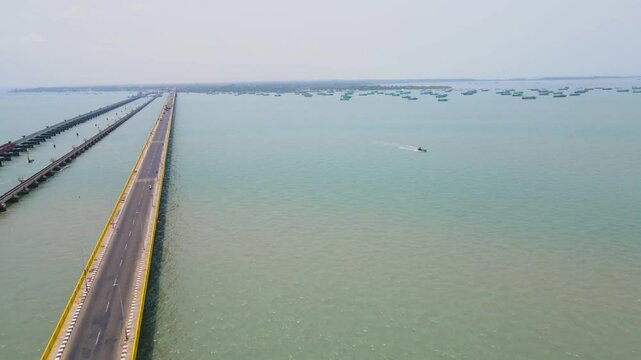 Aerial drone shot of the city of Rameshwaram, featuring the iconic bridge connecting the mainland.