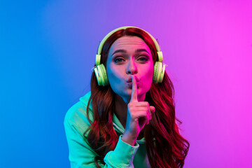 Photo of charming positive woman wear green sweatshirt headphones enjoy songs asking keep silence...