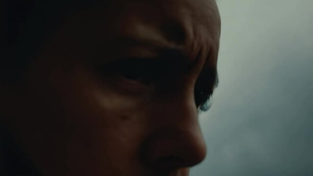 Handheld video with slight shake, cinematic lighting, the camera focuses on an emotional expression, tense scene, dramatic lighting emphasizing mood, intense atmosphere, capturing raw emotion
