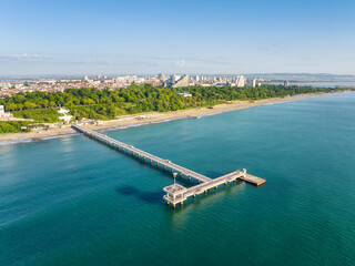 Aerial view of city of Burgas with the sand beach, of the iconic pier and blue waters of the Black Sea in the morning light