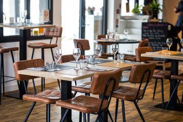 Un restaurant gastronomique vide avec des tables et des chaises et des couverts