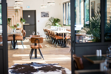 Une salle de restaurant gastronomique moderne avec des chaises en cuir, la salle est très lumineuse