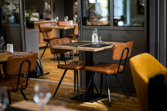 Une table dress&eacute;e dans un restaurant gastronomique avec des chaises en cuir