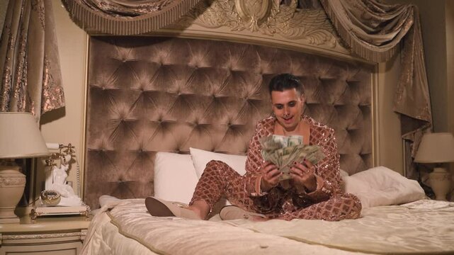 Rich and eccentric man wearing golden suit with a lot of US dollar bills in a luxurious suite