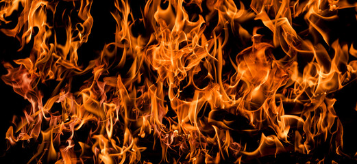 Fire over black background. Fire sparks background. Abstract dark background. Texture of fire on...