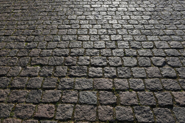 Stone road background texture. Textured background of cobblestone road. Road from brick background. Paving stone and paved road. Sidewalk background.