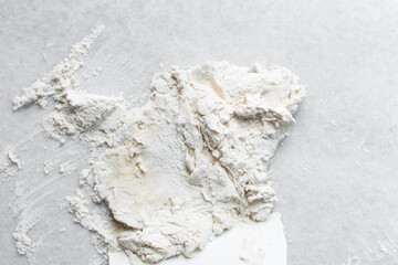 Overhead view of scallion pancake dough being kneaded on a marble countertop, top view of cong you bing dough being kneaded on countertop, process of making scallion pancakes