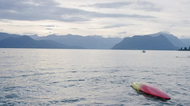 Beautiful view of Canadian lake with capsized canoe and resurfacing swimmer - slow motion