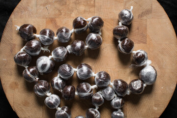 hard candy made with coconut milk and sugar on wood board, Overhead view of nigerian baba dudu candy on wood background, top view of Ghana coconut candy or kube toffee candy