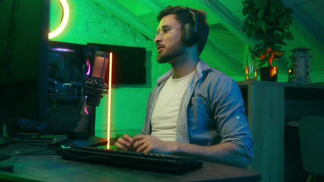 Emotional angry failure upset streamer take off headphones lost bad result problem sad play video game Caucasian man trouble male guy computer gamer cyber stream talking microphone at home dark neon