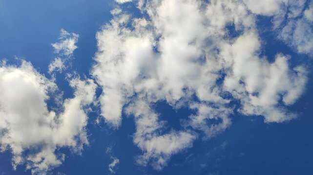 Fast moving white cloud in blue sky on a sunny day. Fast moving and changing cloud in the sky. Cloud in the sky. Bottom view. Atmosphere. Weather. Nature backdrop. Natural background