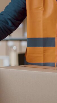 Warehouse worker sealing a box with tape